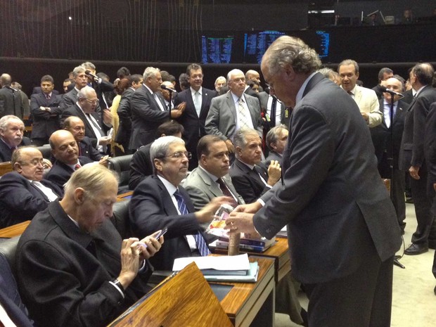 Parlamentares dividem pacotes de bolacha durante a sessão do Congresso (Foto: Fernanda Calgaro / G1)